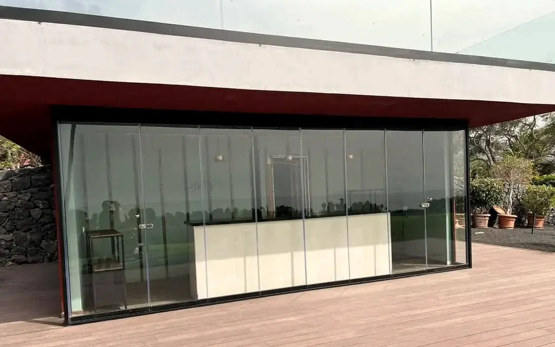 Terraza cerrada con carpintería de aluminio y vidrio sobre suelo de madera